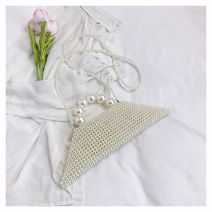 Detail showing white triangular pearl beaded handbag with large handle and chain strap