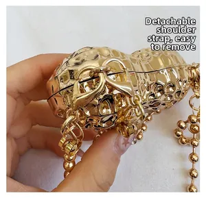 Detail of detachable golden bead chain strap on creative peanut shaped metal evening bag