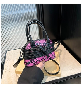 Dettaglio borsa a guscio con motivo serpente rosa e nero con manici e fibbia in metallo