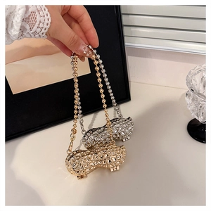 Close-up of metallic peanut-shaped mini bag with realistic texture and bead chain