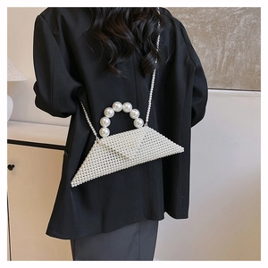 Detail of white pearl woven mini bag with triangular design and elegant chain strap