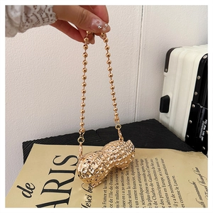 Detailed view of a golden peanut-shaped mini bag with realistic shell texture and bead chain