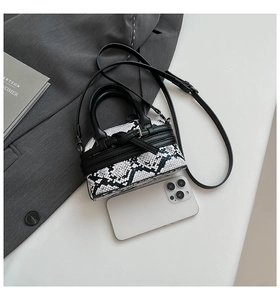Mini borsa a conchiglia pitonata con smartphone per mostrare le dimensioni reali
