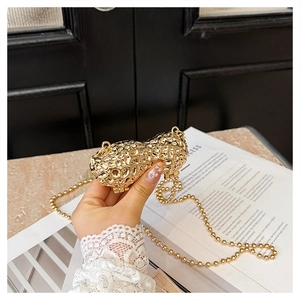 Detailed view of mini golden peanut shaped metal bag with realistic texture and chain