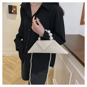 Detail of handmade white pearl woven triangle bag with elegant beaded handle and strap