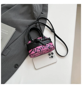 Dettaglio mini borsa a conchiglia con stampa pitonata rosa e nera e manici superiori