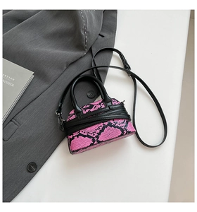 Dettaglio della borsa rosa pitonata su un blazer con tracolla nera regolabile