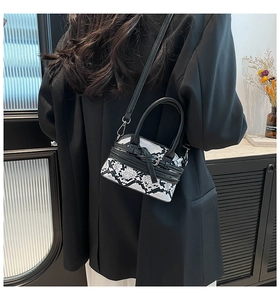 Borsa a tracolla chic con stampa serpente bianca e nera indossata da una modella