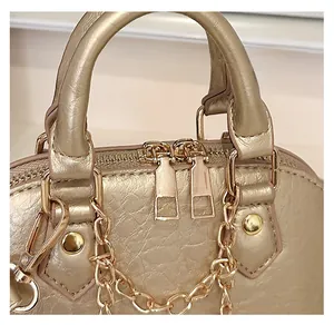Detail of smooth champagne gold zippers and metallic texture on luxury shell handbag