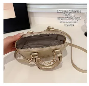 Macro detail of gold leather shell bag interior with pocket and chain strap