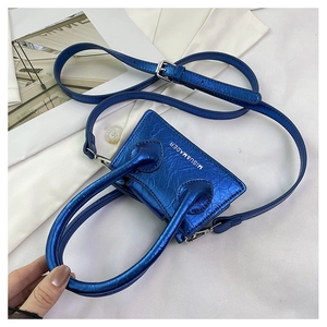 Close-up of blue metallic mini bag with textured finish and brand lettering detail