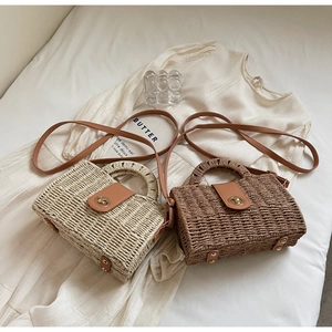 Detail of woven straw tote bags with faux leather flaps and gold clasp closure