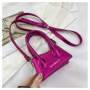 Close-up of mini metallic pink crossbody bag with MISU&MADER logo and silver hardware