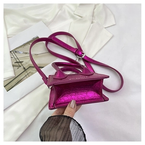 Detail view of mini metallic pink crossbody bag showing compact interior for lipsticks