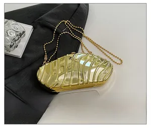 Metallic gold clutch bag with wave texture shown next to a phone for size reference