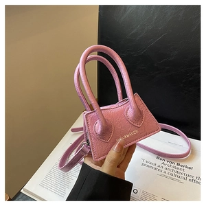 Close-up of a mini pink PU leather crossbody bag with pleated texture and gold logo detail