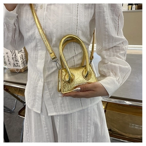 Detailed view of mini metallic gold pleated crossbody bag with a slim shoulder strap