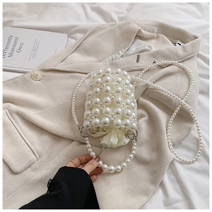Detail view of mini pearl bucket bag with satin drawstring lining and shiny white beads