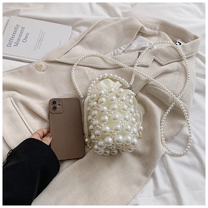 Detailed view of hand-woven pearl bucket bag with drawstring liner and crossbody strap