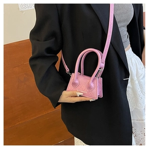 Detail of pink embossed leather mini bag with brand logo and detachable shoulder strap