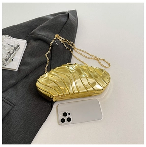 Detail view of gold wavy acrylic evening clutch with metal chain and phone for size reference
