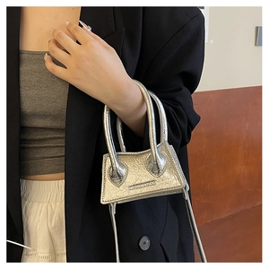 Detail of silver metallic mini handbag with cracked patent finish and dual arc handles