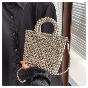 Detailed view of silver beaded mini handbag featuring round metallic beads and chain strap
