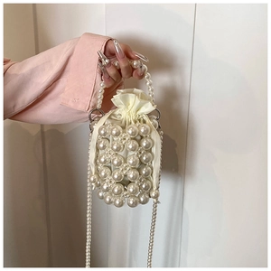 Detailed view of pearl bucket bag with satin drawstring liner and elegant pearl strap