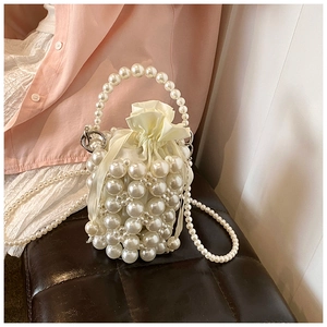 Detail of beaded pearl bucket bag with satin drawstring pouch and detachable strap