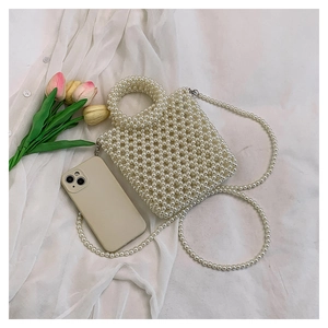 Mini handmade pearl woven bag size comparison with a smartphone on soft white fabric