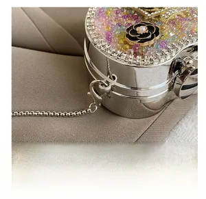 Detail view of the silver chain hook and colorful beadwork on the camellia evening bag