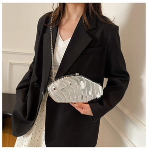 Detailed view of silver shell-shaped acrylic evening clutch with sleek metallic finish