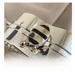 Detailed macro view of silver mirror metal bag with insect-shaped lock and colorful beads