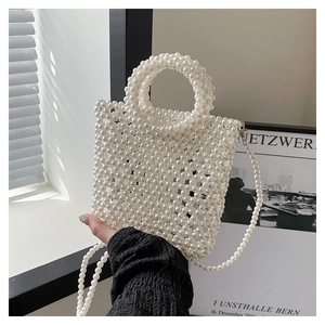 Detailed view of handmade white pearl woven handbag with elegant handle and crossbody chain