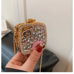 Detailed macro view of rhinestone lip pattern and pearl crown on gold evening clutch