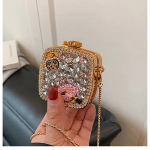 Detail view of mini evening bag with gold frame, crystals, and pink lip decoration
