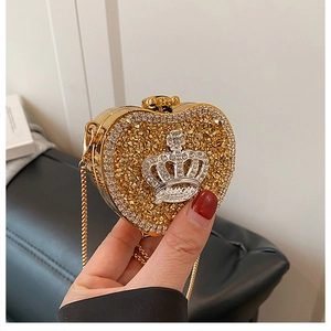 Detailed macro of gold heart evening bag with crystal crown and detachable chain