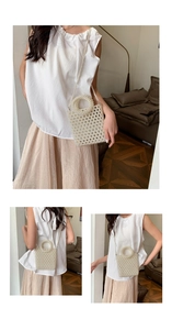 Detail of handmade cream pearl beaded handbag with circular handle and crossbody strap