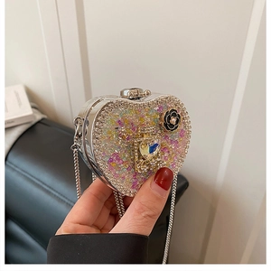 Detail of heart-shaped evening bag with colorful crystals and perfume bottle motif