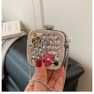 Detail of silver evening bag with crystal rhinestones, gold crown, and pink lip accents