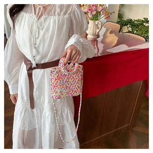 Detailed view of colorful handmade beaded mini bag styled with a white vintage dress