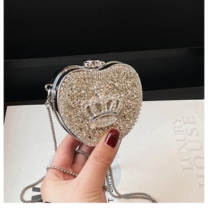 Detailed view of heart-shaped clutch bag with luxury rhinestones and silver crown detail