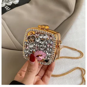 Detail of evening bag featuring pink rhinestone lips and gold chain strap close-up