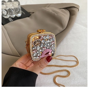 Detail of evening clutch featuring crystal-encrusted pink lips and gold chain strap