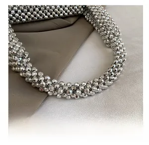 Detail of silver metallic beaded handle showing high-gloss multifaceted craft texture