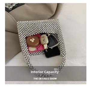 Internal capacity of silver beaded woven handbag showing storage for phone and cosmetics