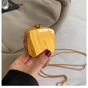 Close-up of golden heart-shaped lipstick bag with luxury rhinestone and chain strap
