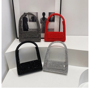 Artistic display of beaded handbags in black, red, silver, and bronze on a white stage