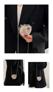 Detailed macro view of heart shaped evening bag with colorful rhinestones and chain
