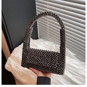 Detailed view of dark grey acrylic beaded shoulder bag with wide woven handle design